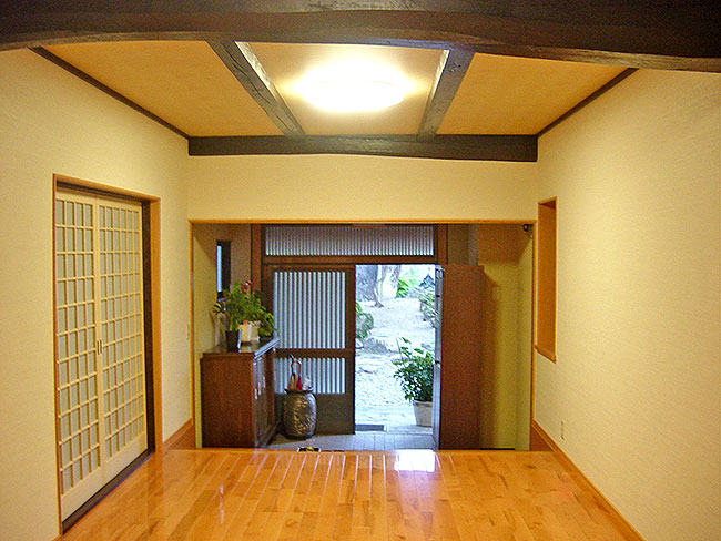 気持ちよくお客様を迎えられる明るくすっきりした玄関に。<br />天井を底上げしたことで覗いた梁が、玄関に表情を作り出しています。