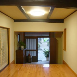 気持ちよくお客様をお迎えできる、明るくすっきりした玄関に。<br>天井を底上げしたことで覗いた梁が、玄関に表情を作り出しています。