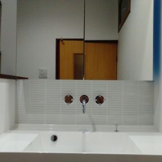 グレーのタイルに白の目地がシンプル。水栓金具のブラウンが引き立つ。