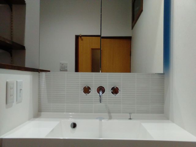 グレーのタイルに白の目地がシンプル。水栓金具のブラウンが引き立つ。